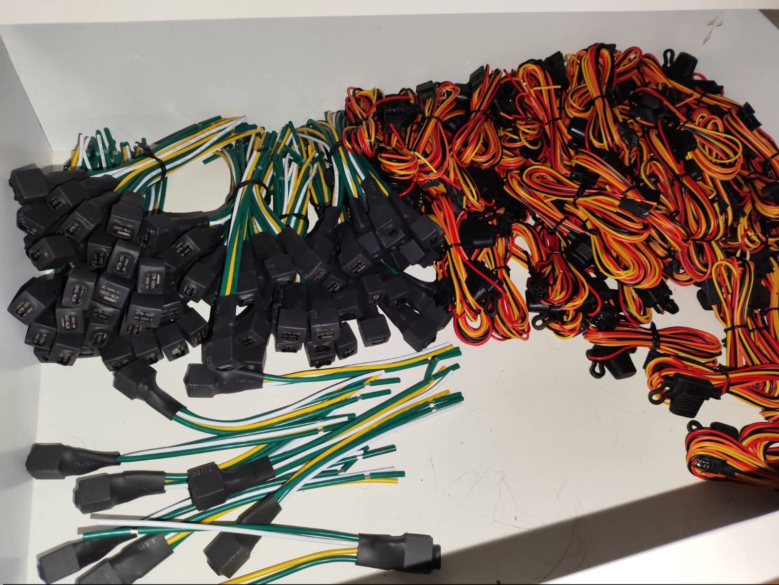 conjunto de chicotes elétricos com fios coloridos (verde, amarelo, branco, vermelho, laranja, preto) e conectores plásti