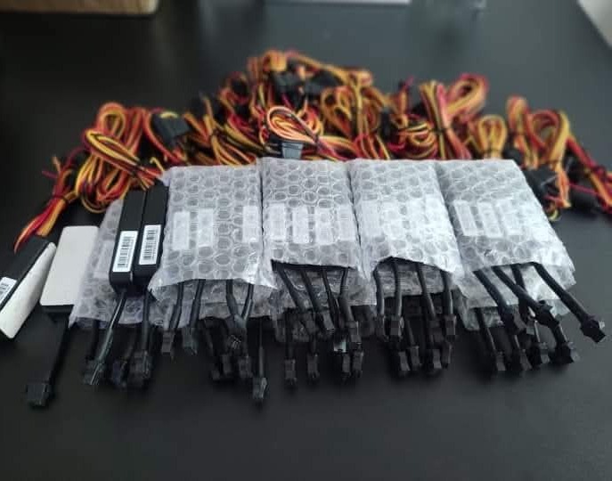 conjunto de fitas de LED com cabos e conectores coloridos dispostos sobre superfície escura